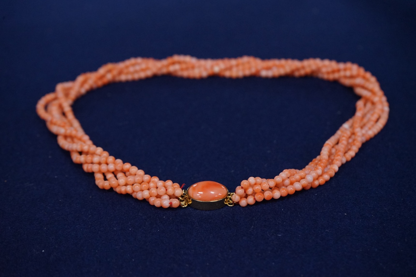 A multi strand coral bead necklace, with cabochon coral set gilt metal clasp, 47cm.